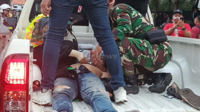 Petugas Mer-C dan personel TNI memberikan pertolongan kepada seorang demonstran yang tumbang terkena gas air mata dalam demo ricuh di depan Mako Brimob Kwitang, Jakarta Pusat, Jumat (29/8/2025). [FTNews.co.id/Selvianus Kopong Basar]